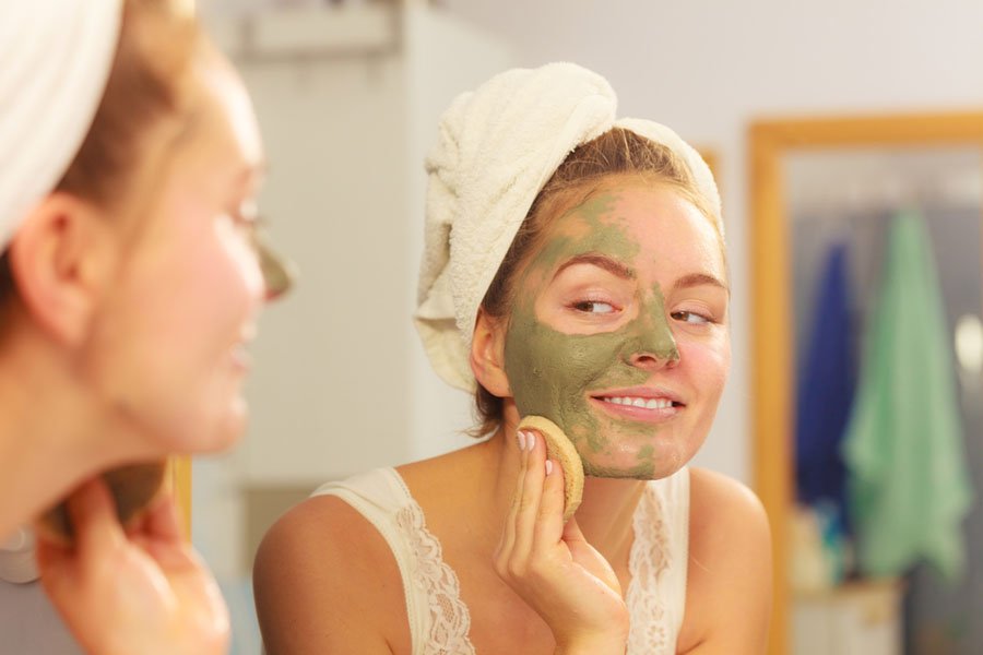 femme appliquant un masque facial