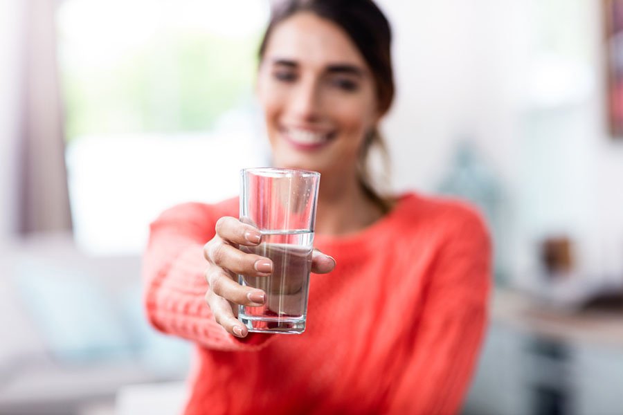 femme tenant un verre d'eau