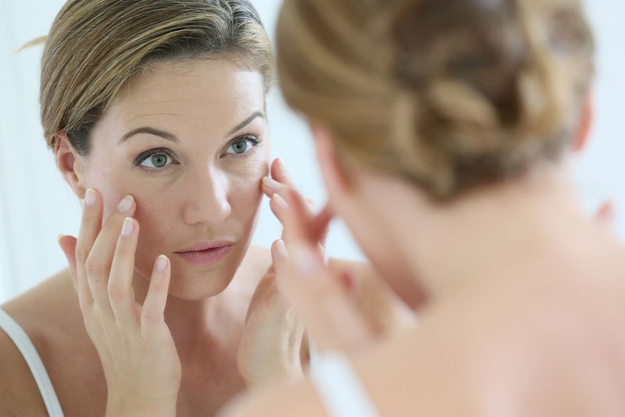 Femme d'âge moyen appliquant une crème anti-âge