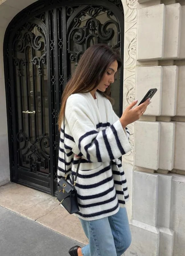 Influenceuse au look de bureau composé d'un cardigan rayé, d'un jean et de ballerines à talons hauts/@wendyswan