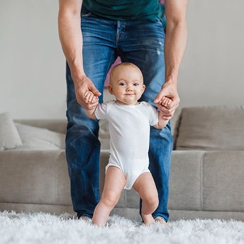 Bébé marche avec l'aide de papa