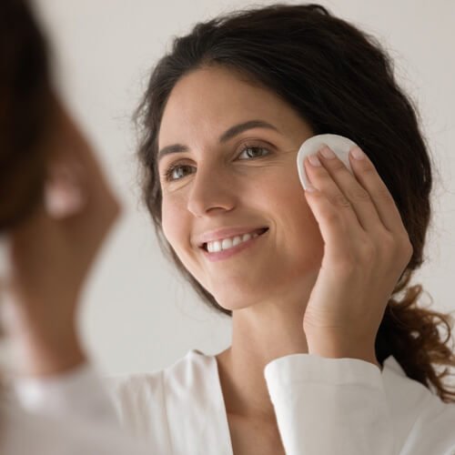 Femme rembourrant le visage avec du coton