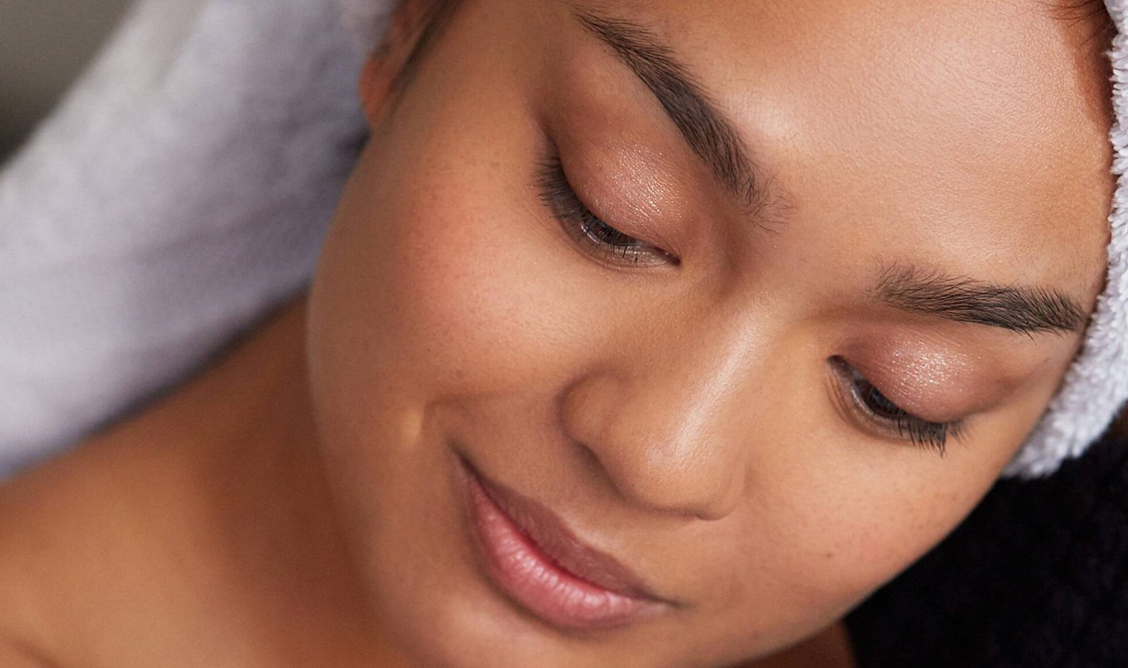 close-up of person smiling and wearing towel on head