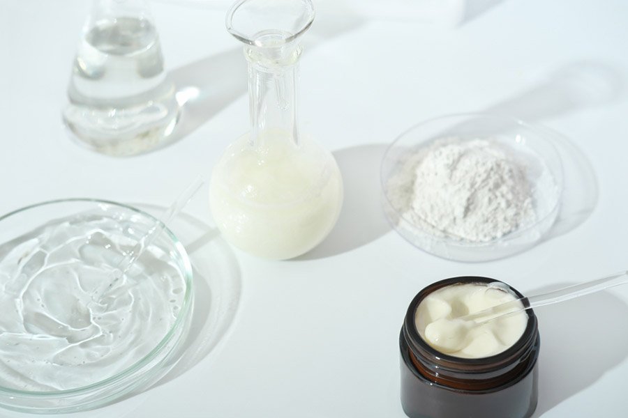 plats de laboratoire et verrerie sur une table de laboratoire.  fermentation, soins de la peau de beauté fermentés.  récipient avec crème ou solution ou sérum pour traitement anti-âge, ingrédient cosmétique en poudre